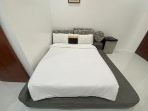 CabanganQ Beach Resort的卧室配有一张带白色床单和枕头的大床。