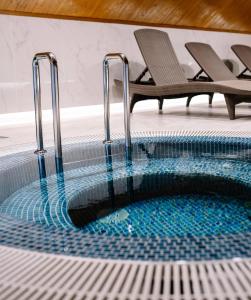 UngureniPodina Resort Hotel & Spa的游泳池旁设有两把椅子