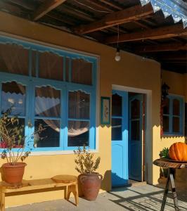 舍基Guest House Ruh Achari的蓝色窗户和长凳的房子