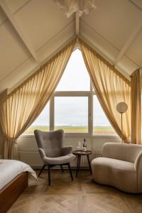 羊角村B&B Giethoorn的卧室配有床、椅子和窗户。