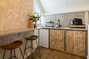羊角村B&B Giethoorn的厨房配有木制橱柜和2张凳子