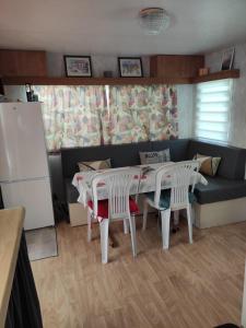 孔夫朗自由城MOBIL HOME CAMPING 3***的厨房配有桌椅和沙发。