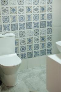 卡兹贝吉SMART Via Kazbegi的浴室设有卫生间,铺有蓝色和白色瓷砖。