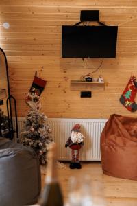 卡兹贝吉SMART Via Kazbegi的一间设有圣诞树的客房,墙上设有一台电视机