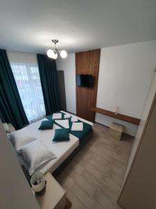 北马马亚-讷沃达里ALZ Beach Apartments in Alezzi Beach Resort的一间卧室配有一张带绿色枕头的大床