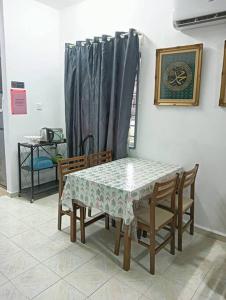 马六甲Homestay HNH Melaka (Corner Lot)的餐桌、椅子、桌子和窗帘