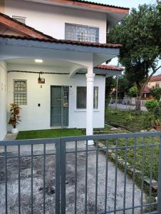 马六甲Homestay HNH Melaka (Corner Lot)的前面有栅栏的白色房子