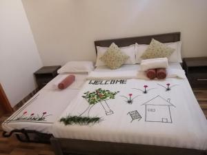 韦利杜岛Sabba Beach Suite , Fodhdhoo - Maldives的一张带白色棉被和鲜花的床