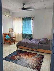 马六甲Homestay HNH Melaka (Corner Lot)的卧室配有床、椅子和窗户。