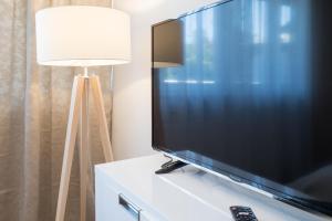 美因茨MA-LIVING Miralior Apartment Mainz的梳妆台上带台灯的平面电视