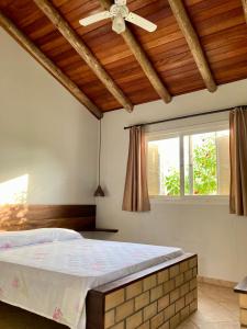 雅瓜鲁纳Pousada dos Sambaquis的一间卧室配有一张床和吊扇