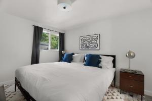 西雅图Blueground Beacon Hill nr groceries parks SEA-702的白色卧室配有一张带蓝色枕头的大床