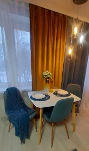纳尔瓦The Best Choice Narva Center的餐桌、两把椅子和花瓶