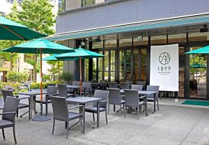 东京龙名馆酒店御茶水总店的一个带桌椅和遮阳伞的户外庭院。