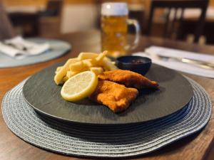 Wäschenbeuren加斯托夫瓦赛施罗斯酒店的一小盘带鱼片和薯条的食品和柠檬