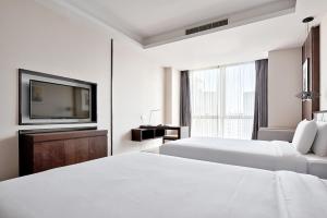 重庆重庆MontClassic精选酒店的白色的酒店客房 - 带2张床和电视