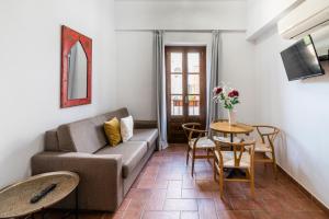 科尔多瓦La Jⲟya de los Patios - Apartamentos Turísticos的客厅配有沙发和桌子
