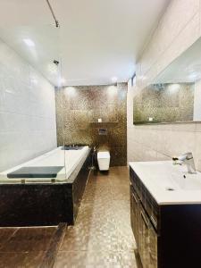 新德里Hotel Gold Souk - Karol Bagh的带浴缸、盥洗盆和卫生间的浴室