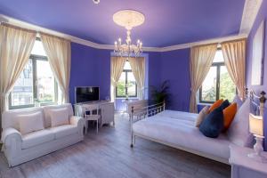 魏玛奥博格吉安卡洛大酒店的客厅设有紫色墙壁、沙发和椅子