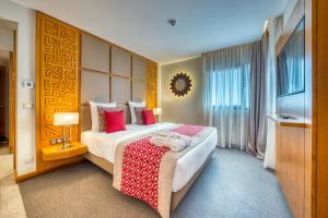 达喀尔Azalaï Hôtel Dakar的酒店客房配有一张带红色枕头的大床