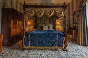 莫希尔林恩湖城堡酒店的一间卧室配有一张带蓝色棉被的床