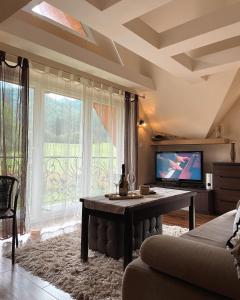 扎科帕内HELLO GIEWONT的客厅配有桌子、电视和窗户。