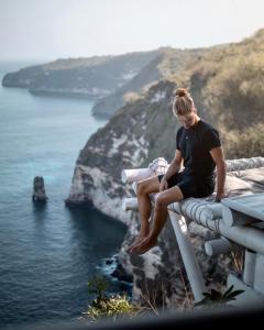 珀尼达岛Tropical Glamping Nusa Penida Diamond Beach - Cliff Side Edge的坐在领海的女人