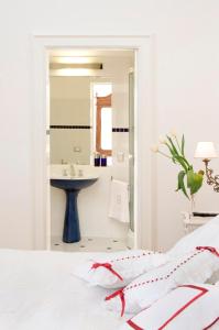 莱切德吉奥吉宫殿住宿加早餐旅馆的白色卧室设有水槽和一张床