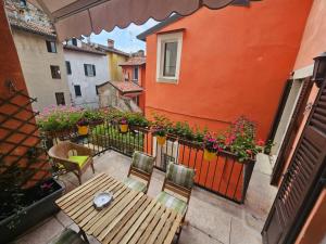 布雷西亚Il Cortiletto- Le Piazze的阳台配有木桌、椅子和鲜花
