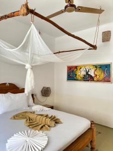 帕杰Mlango Paje House II的一间卧室配有一张带吊扇的床