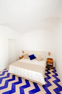 伊斯基亚大拉斐尔酒店 的卧室配有床,铺有蓝色和白色的地板