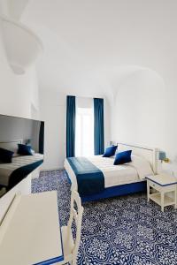 伊斯基亚大拉斐尔酒店 的配有一张床、一张桌子和一张桌子的酒店客房