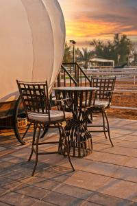 拉斯阿尔卡麦Nirvana Retreat的屋顶上配有两把椅子和一张桌子及一把遮阳伞
