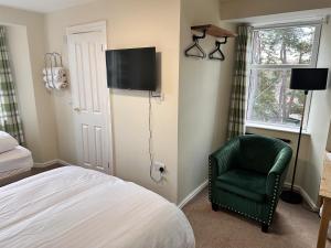 金克雷格Forces Manor的一间卧室配有一张床和一把绿色椅子
