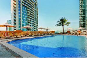 迪拜HOMESTAR, Jumeirah Beach Hostel - JBR - Pool, Beach, Metro的一个带椅子和遮阳伞的大型游泳池
