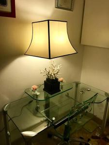 都灵Accogliente Trilocale in Gran Madre的玻璃桌上的一盏灯,上面有玻璃桌, ⁇ 丝