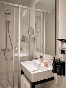 阿姆斯特丹Max Brown Hotel Museum Square, part of Sircle Collection的白色的浴室设有水槽和淋浴。