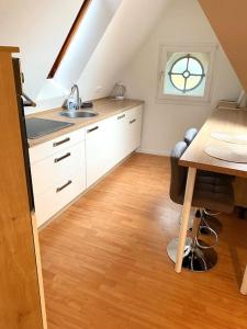 汉诺威gemütliches Apartment Döhren的厨房配有水槽、桌子和窗户