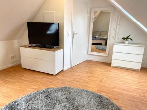 汉诺威gemütliches Apartment Döhren的客厅配有梳妆台上的平面电视