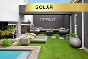弗朗斯胡克Le Petit Bijou Boutique Apartments - Solar Power的一个带游泳池和绿草的庭院