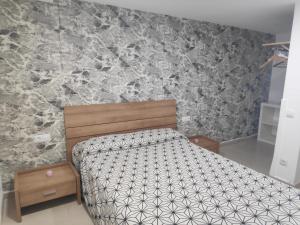 巴尔罗马内斯Apartamento independiente en plena naturaleza Vallromanes Barcelona的一间卧室设有一张床和石墙