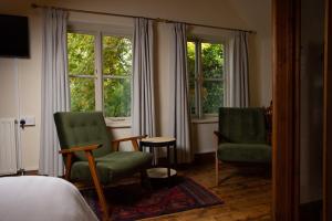利德福德Castle Inn的一间卧室配有两把椅子和一张床,设有窗户。