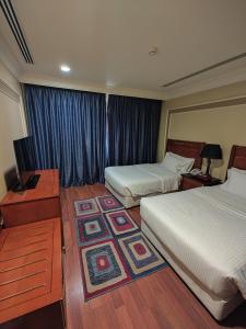 阿可贺巴فندق كارم الخبر - Karim Hotel Khobar的酒店客房配有两张床和一张书桌