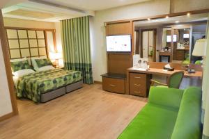 雅温得UNITED HOTEL INTERNATIONAL的配有一张床和一张书桌的酒店客房