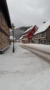 瓦尔肯里德Mittel-Schänke Wieda的一条有建筑物和灯杆的雪覆盖的街道