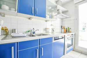 马赛Le Pharo - Plage des Catalans et métro Vieux-Port的厨房配有蓝色橱柜和水槽