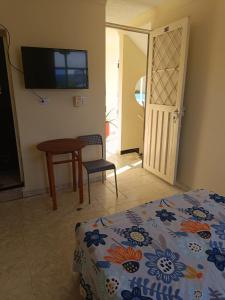 梅尔加Cambulos House的一间卧室配有一张床、一张桌子和一台电视