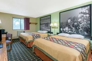 特温斯堡特温斯堡速8酒店的酒店客房设有两张床,墙上挂着一张大照片。