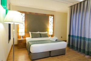 雅温得UNITED HOTEL INTERNATIONAL的一间卧室配有床、灯和窗户