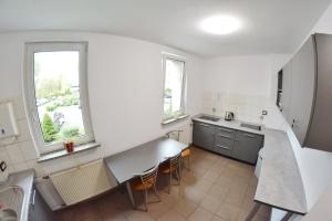 比托姆Noclegi Bytom - OPAL的厨房拥有白色的墙壁和桌椅